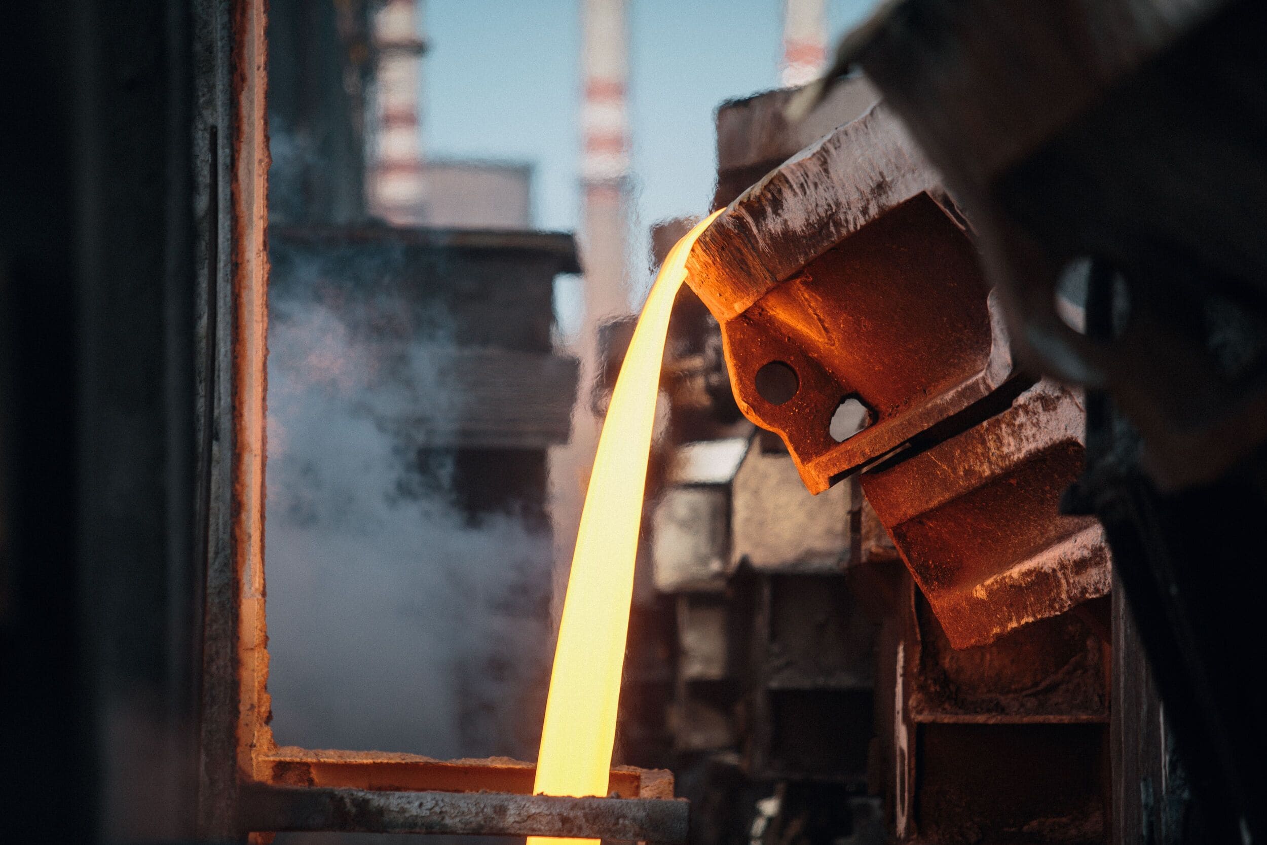 Molten metal pouring from a ladle at a foundry